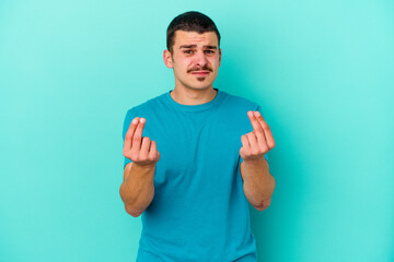 Young caucasian man isolated on blue background showing that she has no money.