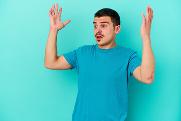 Naklejka premium Young caucasian man isolated on blue background screaming to the sky, looking up, frustrated.