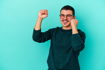 Young caucasian man isolated on blue background dancing and having fun.