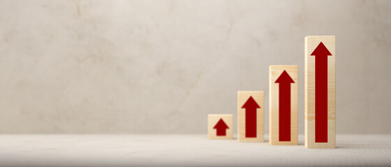 Ascending bar graph on wooden blocks with red arrows