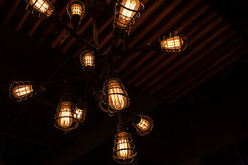 A constellation of red-hot incandescent light bulbs encased in metal iron spirals, chandelier fixture in a restaurant in London, Ontario, Canada, 2021.