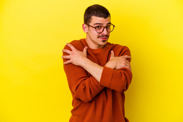 Fototapeta premium Young caucasian cool man isolated on yellow background hugs, smiling carefree and happy.