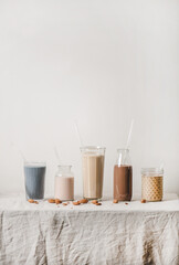 Almond dairy-free milk with matcha, berries, cocoa, coffee in bottles