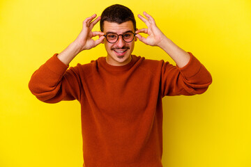 Fototapeta na wymiar Young caucasian cool man isolated on yellow background excited keeping ok gesture on eye.