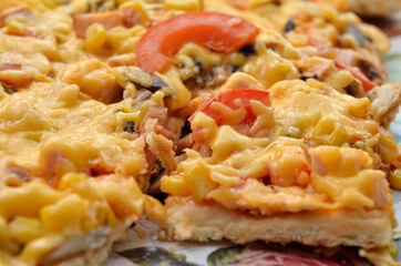 Freshly baked pizza, melted cheese and vegetables close-up.