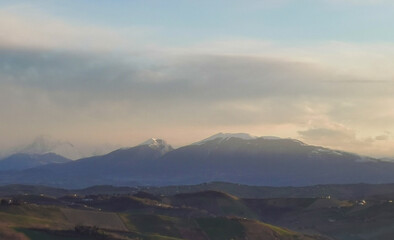 Obraz na płótnie Canvas Montagne dalle cime innevate dell’Appennino e valli illuminate dal sole invernale