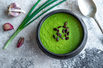 Broccoli and avocado soup in black ceramic bowl, dietary vegetable food