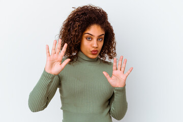 Young african american woman isolated on white background rejecting someone showing a gesture of...