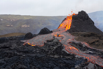 GELDINGADALIR, ICELAND - MARCH 21, 2021: A small volcanic eruption started at the Reykjanes peninsula. The event has attracted thousands of visitors who have braved a daring hike to the crater.