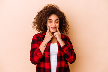 Young african american woman isolated on beige background doubting between two options.