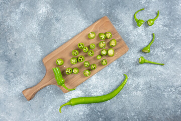 Sliced jalapeno peppers on wooden marble board