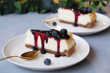 Vanilla cheesecake with blueberries. Two plates of sweet delicious slices of cheesecake.