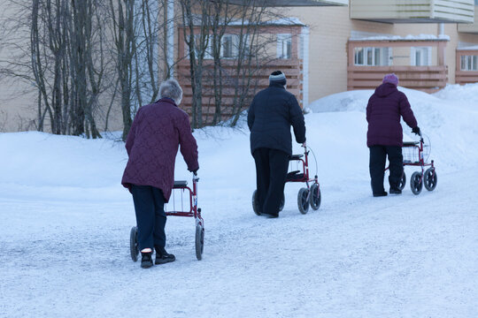Umea, Norrland Sweden - March 4, 2021: three elderly people are out with their walkers