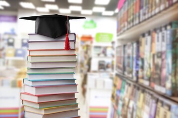 Stack school books with a black graduation hat