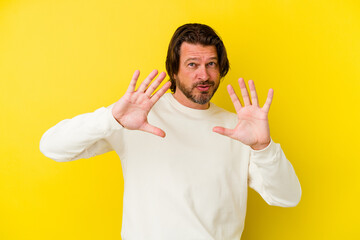 Middle age caucasian man isolated on yellow background rejecting someone showing a gesture of disgust.