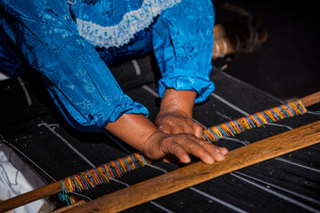 Hands of an artisan woman working on her loom - obrazy, fototapety, plakaty