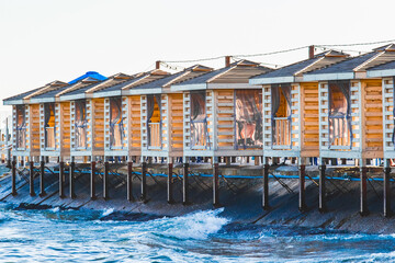 Wooden holiday houses on the sea pier near the water and the beach