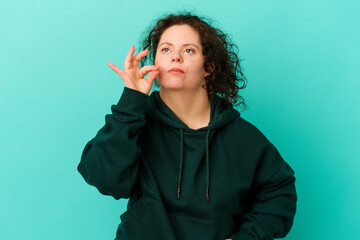 Obraz premium Woman with Down syndrome isolated with fingers on lips keeping a secret.