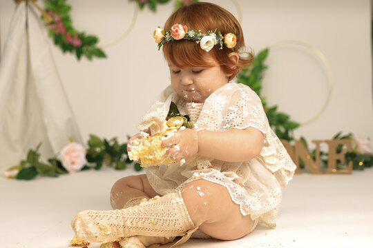 little girl smashes a cake on his first birthday. Smash cake, stylized photo session for a children's party