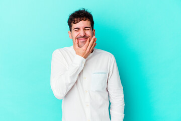 Young caucasian man isolated on blue background doubting between two options.