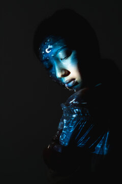 Art Portrait. Cosmic Beauty. Universe Wisdom. Blue Asian Alien Woman Face Silhouette With Abstract Texture Light Isolated On Black Background.