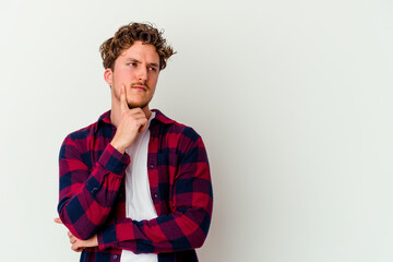 Obraz premium Young caucasian man isolated on white background looking sideways with doubtful and skeptical expression.