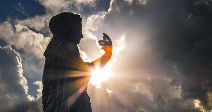 A religious statue of Mary against an stormy sky with clouds passing by. Time Lapse. Faith concept