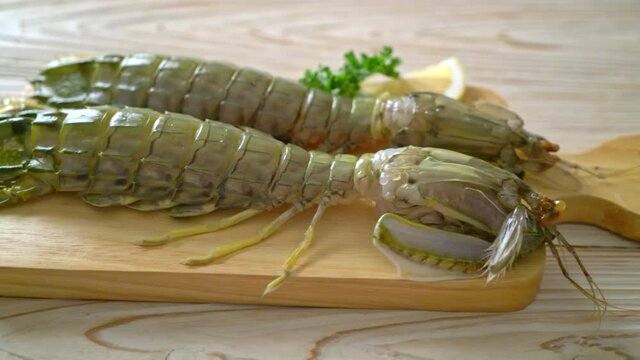 fresh mantis shrimp with lemon on wood board