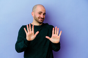 Young caucasian bald man isolated on purple background rejecting someone showing a gesture of...