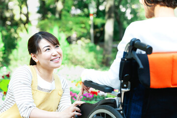 車椅子に乗ったシニア女性と話す女性介護士