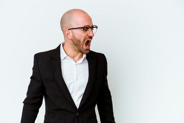 Young business caucasian bald man isolated on blue background shouting very angry, rage concept, frustrated.