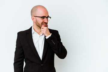 Young business caucasian bald man isolated on blue background touching back of head, thinking and making a choice.