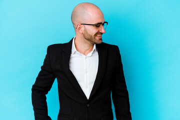 Young business caucasian bald man isolated on blue background laughs and closes eyes, feels relaxed and happy.