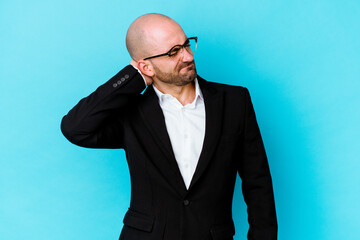 Young business caucasian bald man isolated on blue background having a neck pain due to stress, massaging and touching it with hand.