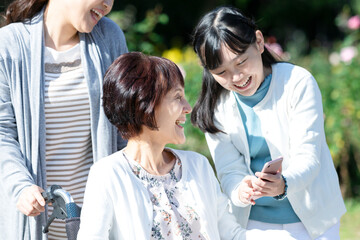  車椅子に座る祖母と笑顔の母娘