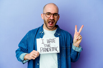 Young caucasian bald man holding a I hate the pandemic placard isolated on blue background joyful...
