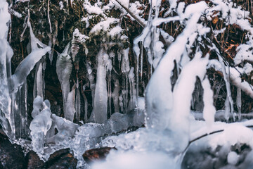 Ice and icicles hanging from a rock along a creek
