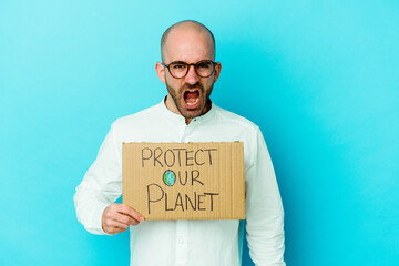 Young caucasian bald man holding a protect our planet placard isolated on purple background...