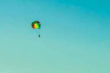 A man and a woman tourists are parachuting against the blue sky. Extreme vacation concept
