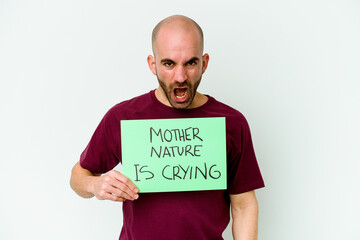 Young caucasian bald man holding a Mother Nature crying isolated on white background screaming very angry and aggressive.