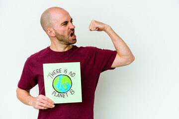 Young caucasian bald man holding a there is not planet B placard isolated on purple background raising fist after a victory, winner concept.