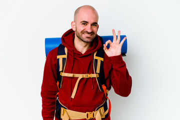 Young caucasian backpacker bald man isolated on white background cheerful and confident showing ok gesture.