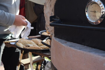 cocinando empanadas en horno de barro