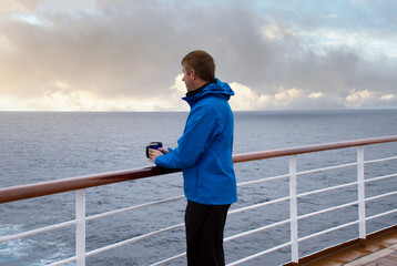 Man looking from stern of boat out into sea