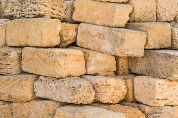 Heap of brick shell blocks sand stone texture background, close-up