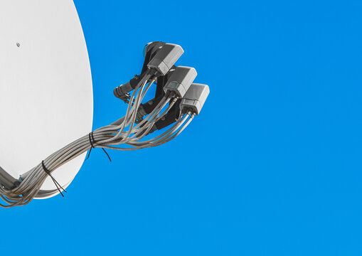 Feedhorn of a satellite dish against a blue sky, close-up