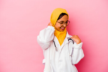 Young doctor muslim woman isolated on pink background stretching arms, relaxed position.