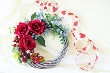 ハートのリボンと赤いバラとローズヒップのゴージャスなリース（白布の背景）