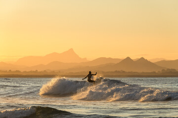 Obraz na płótnie Canvas Surfing at sunset, Byron Bay Australia