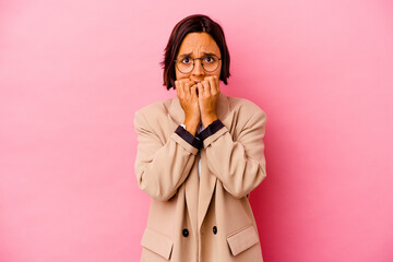 Young business mixed race woman isolated on pink background biting fingernails, nervous and very anxious.